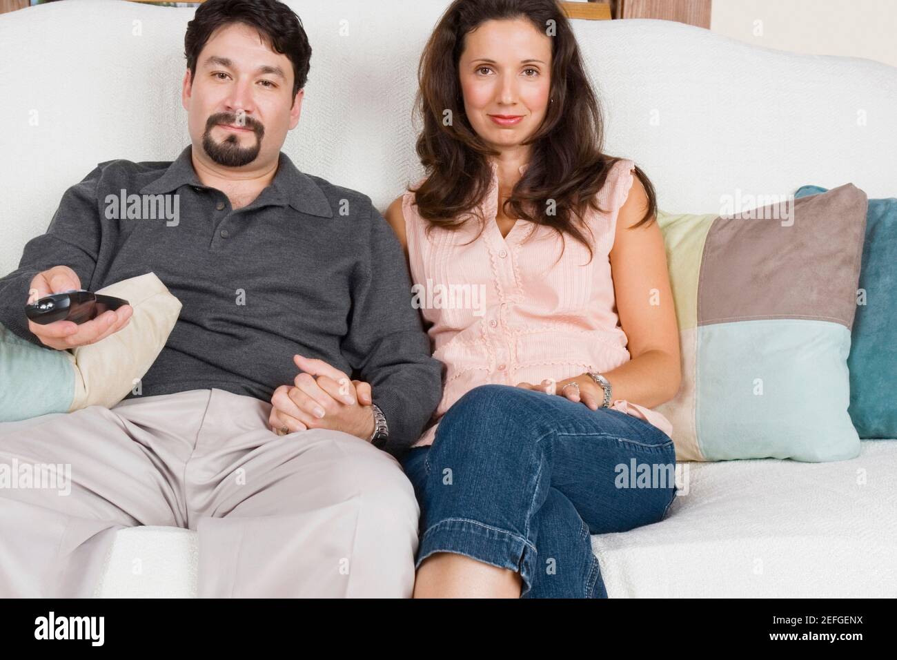 Portrait of a mid adult couple watching television Stock Photo