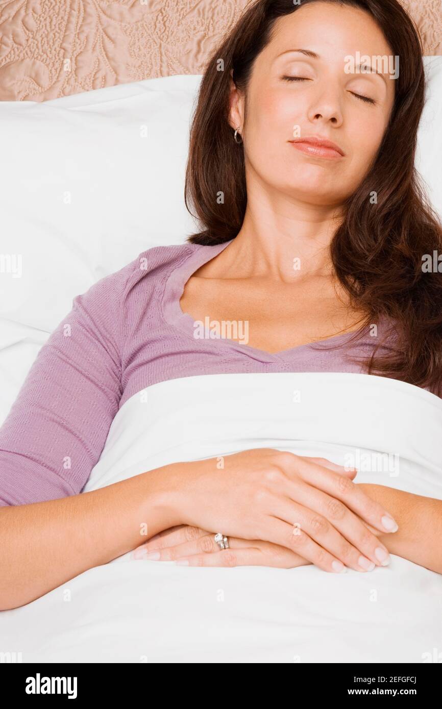 Close-up of a mid adult woman sleeping on the bed Stock Photo - Alamy