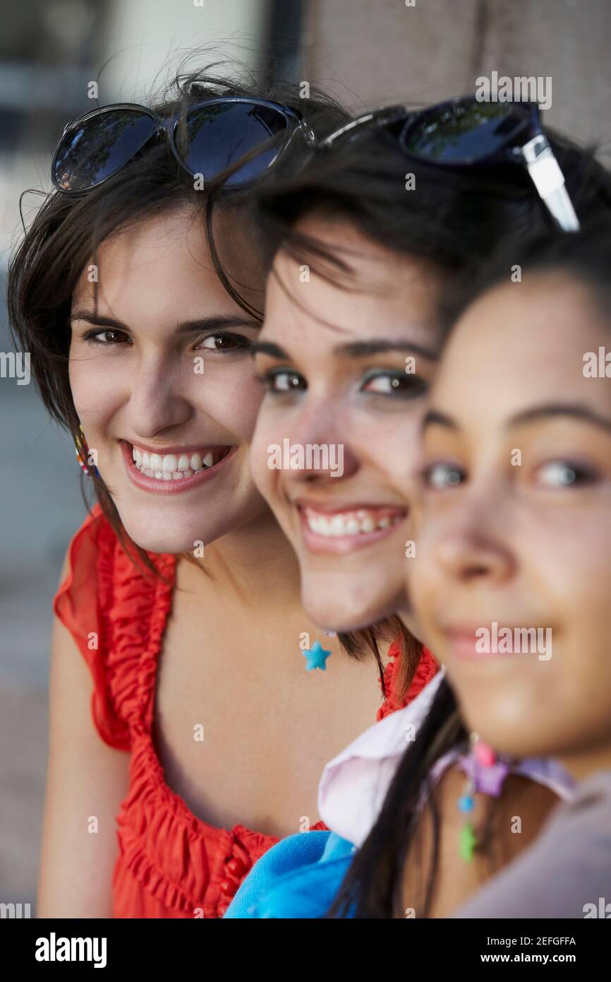 Portrait of three young women sitting and smiling Stock Photo - Alamy