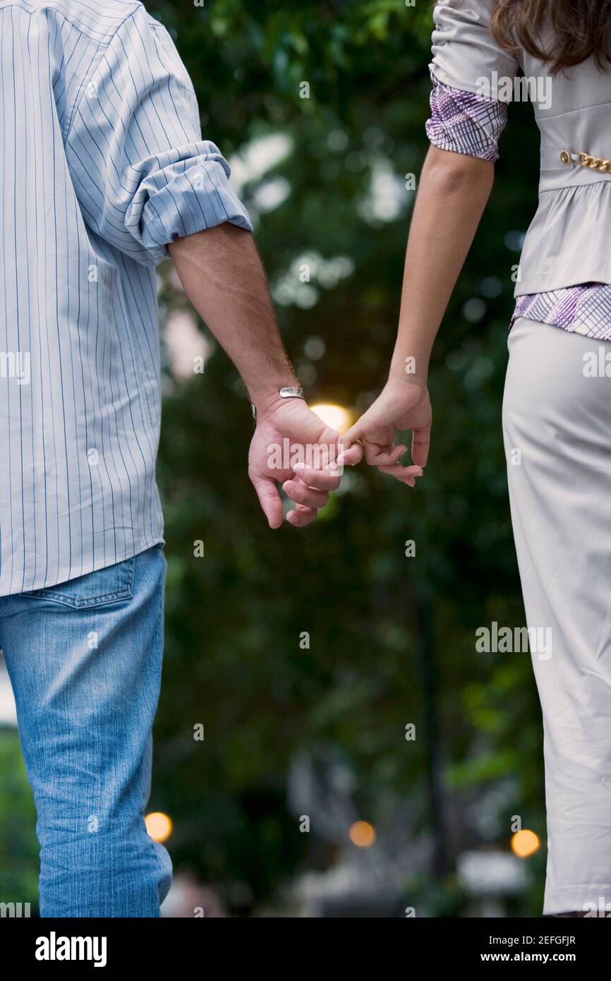 Rear view of a young couple holding hands of each other Stock Photo