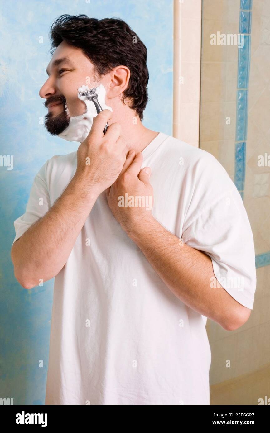 Mid adult man shaving in the bathroom Stock Photo Alamy