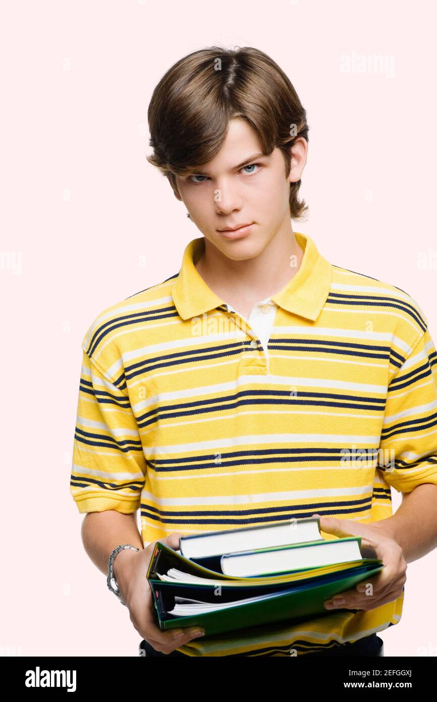 Portrait of a teenage boy holding books and ring binders Stock Photo ...