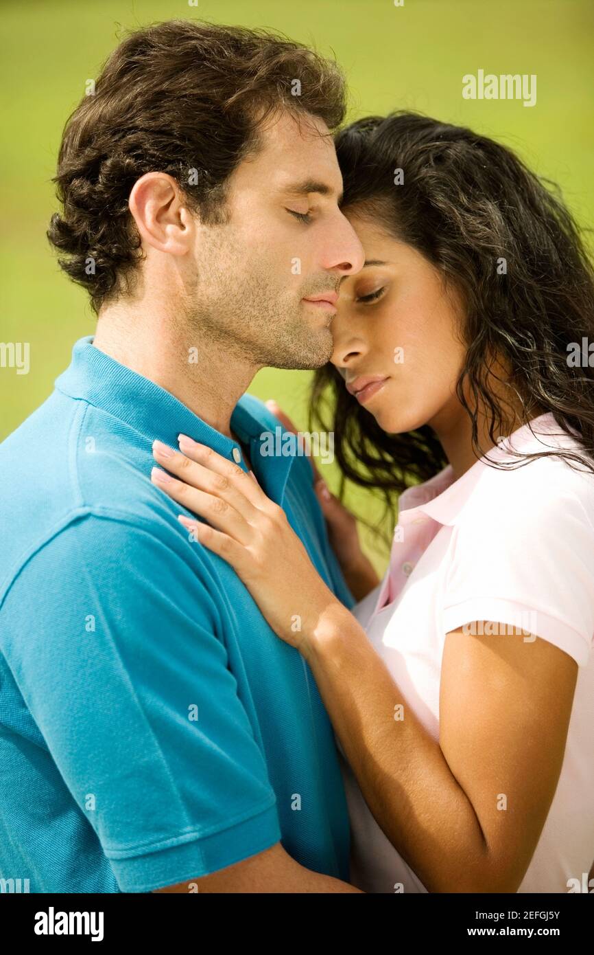 Side profile of a mid adult man embracing a young woman Stock Photo - Alamy