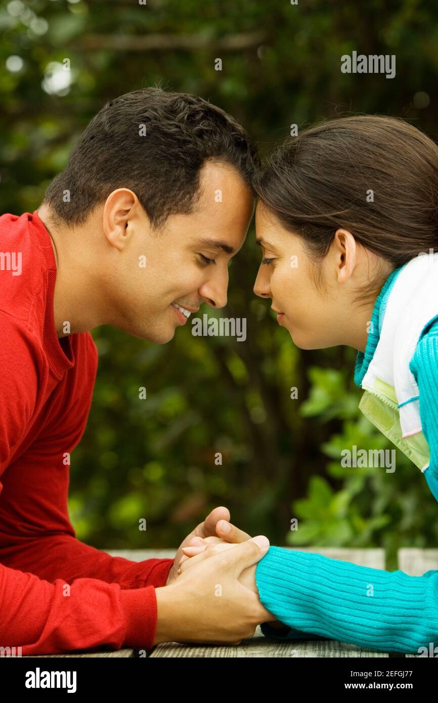 Side profile of a young man holding a young womanÅ½s hand Stock Photo ...
