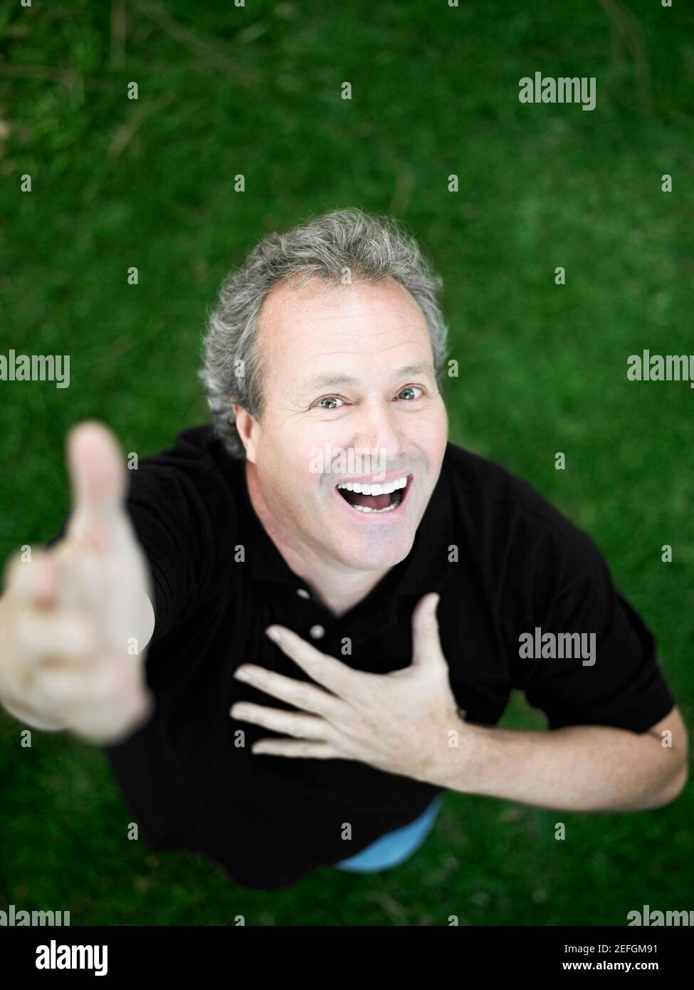 Portrait of a mature man standing in the park and smiling Stock Photo