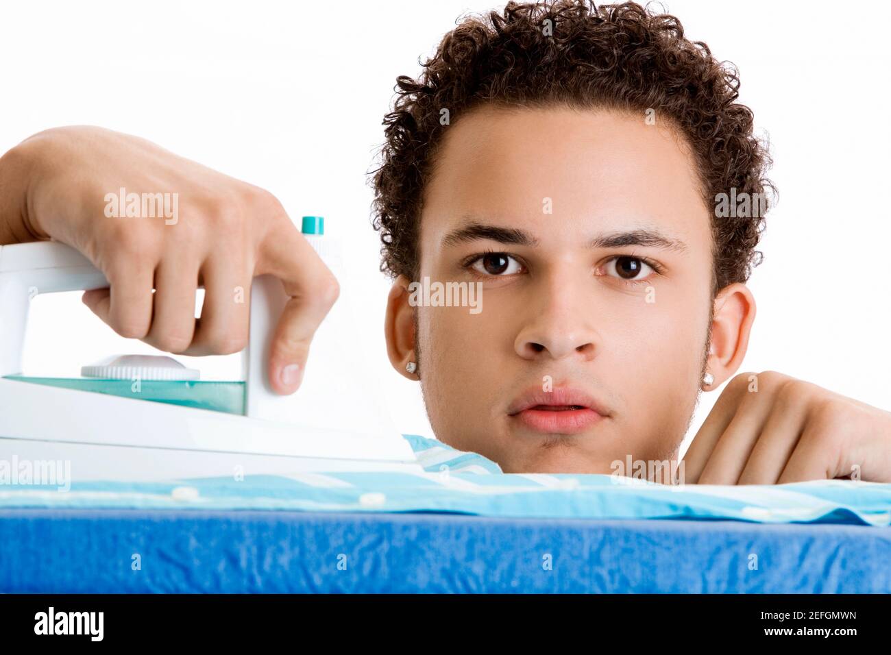 Portrait of a young man ironing his shirt Stock Photo