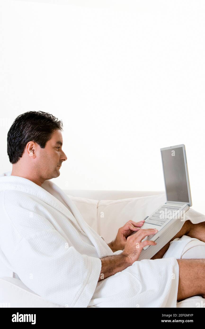 Side profile of a mid adult man working on a laptop Stock Photo