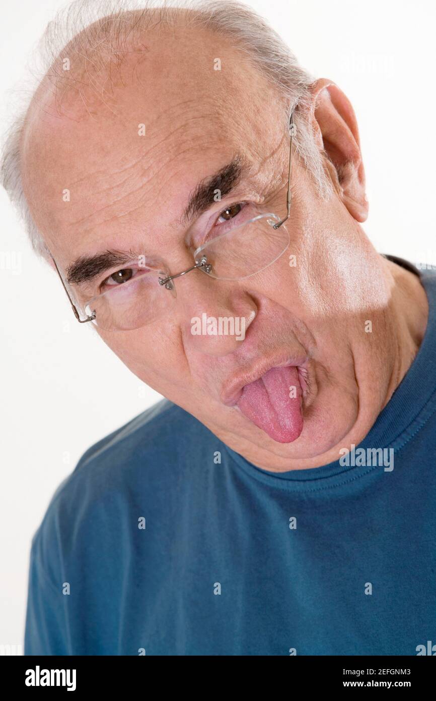 Portrait of a senior man sticking out his tongue Stock Photo - Alamy