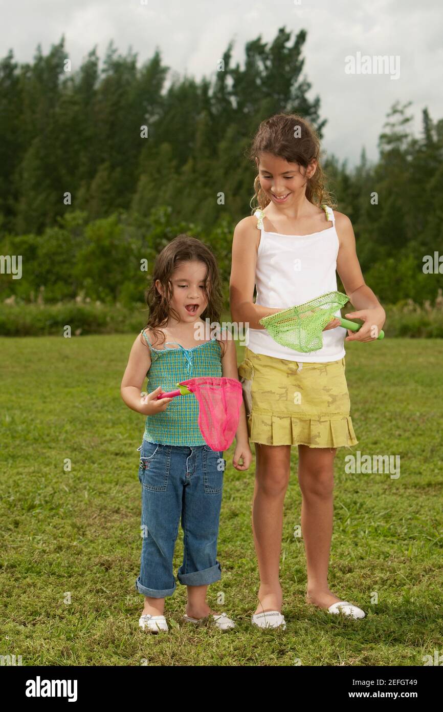 Two girls looking at a butterfly net Stock Photo