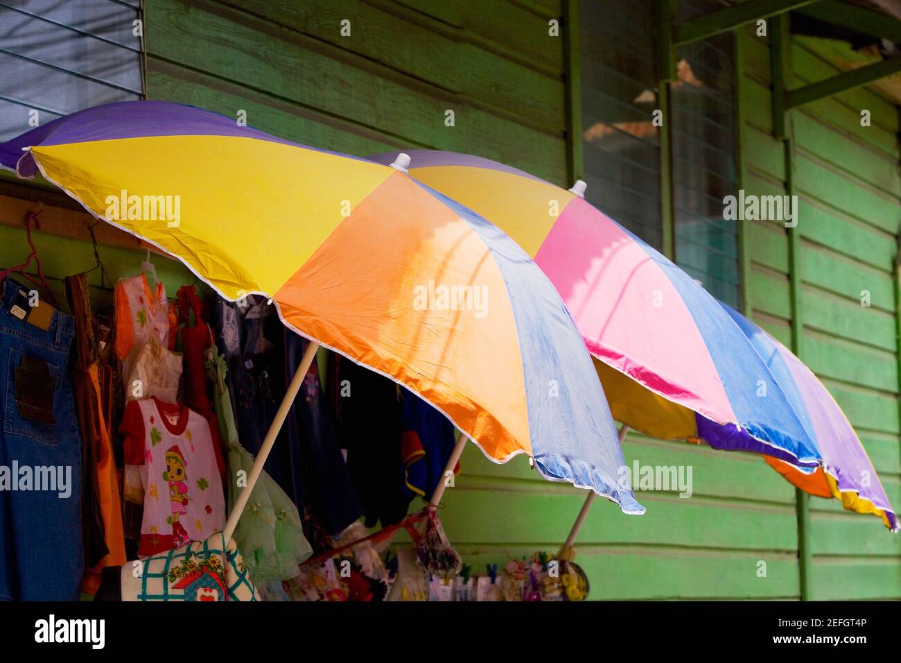 Three umbrellas with clothes in a clothing store, Coxen Hole, Roatan