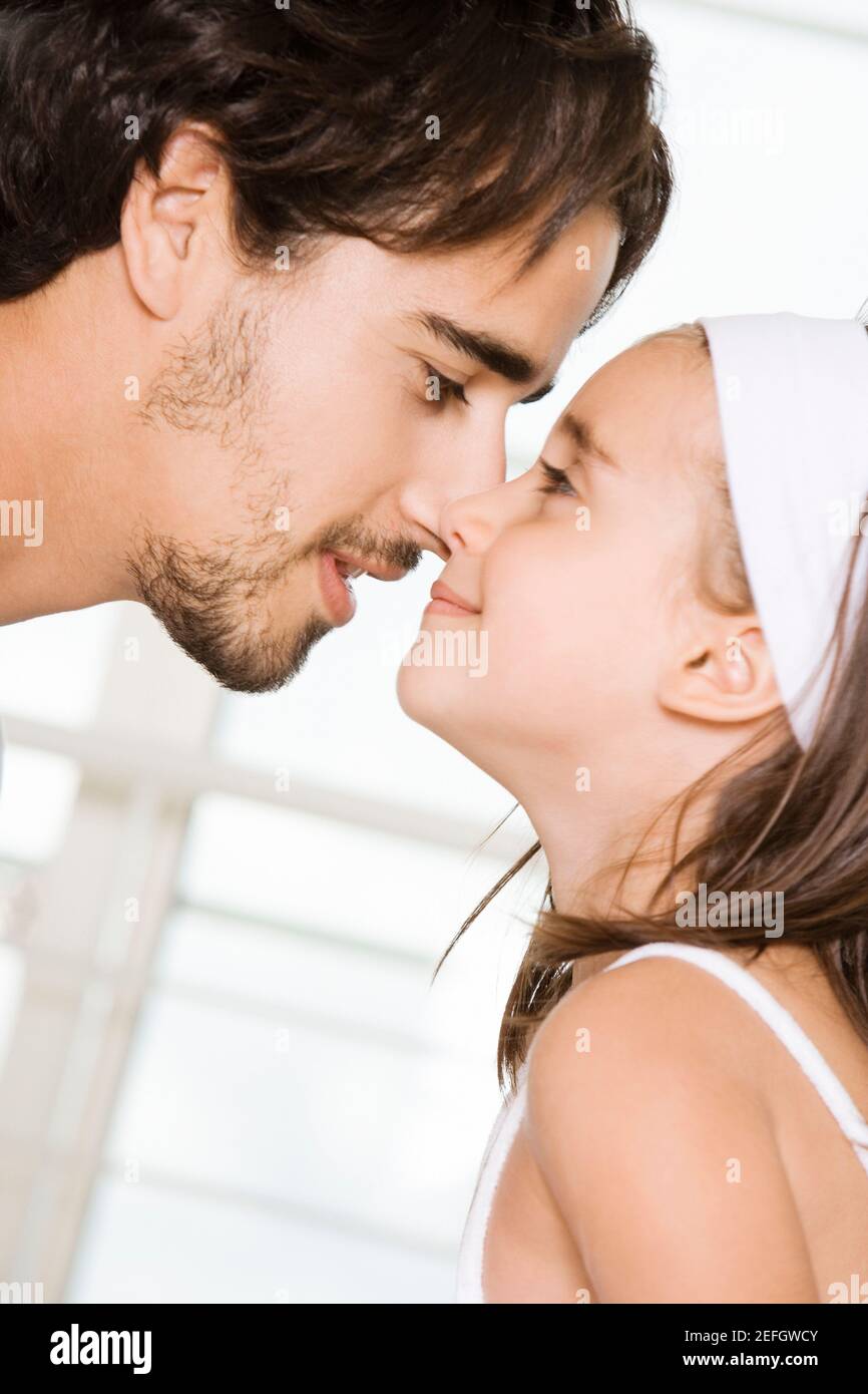 Side profile of a father and his daughter nuzzling Stock Photo