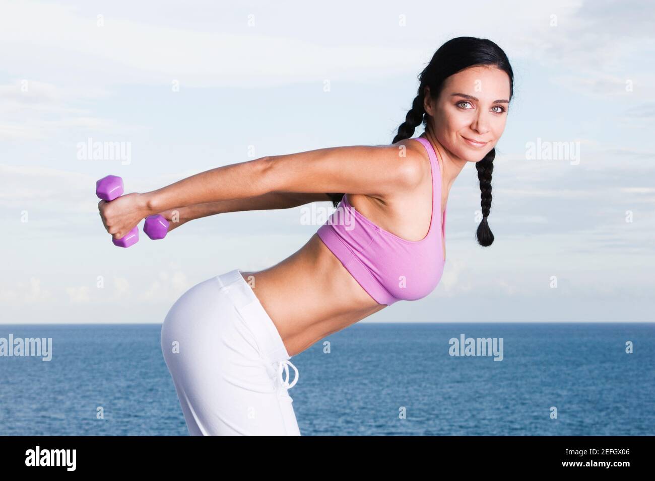 Portrait of a young woman exercising with dumbbells Stock Photo