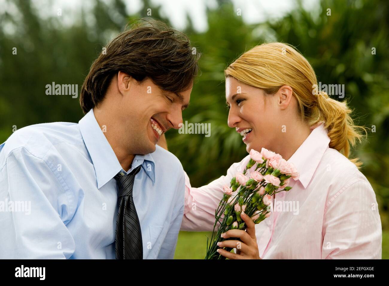 Close-up of a businessman and a businesswoman smiling in the park Stock Photo