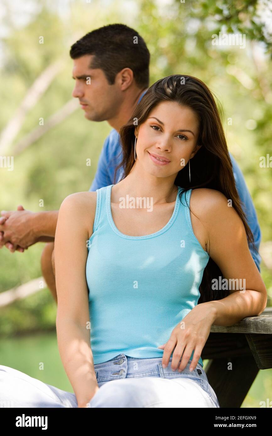 Portrait of a young woman with a mid adult man standing behind her ...