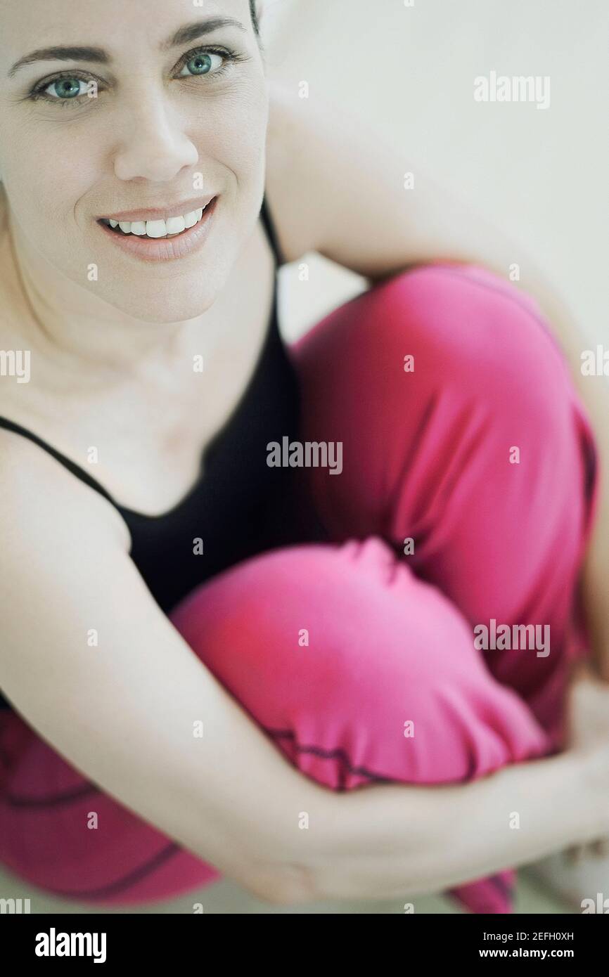 Portrait of a mature woman smiling and hugging her knees Stock Photo ...