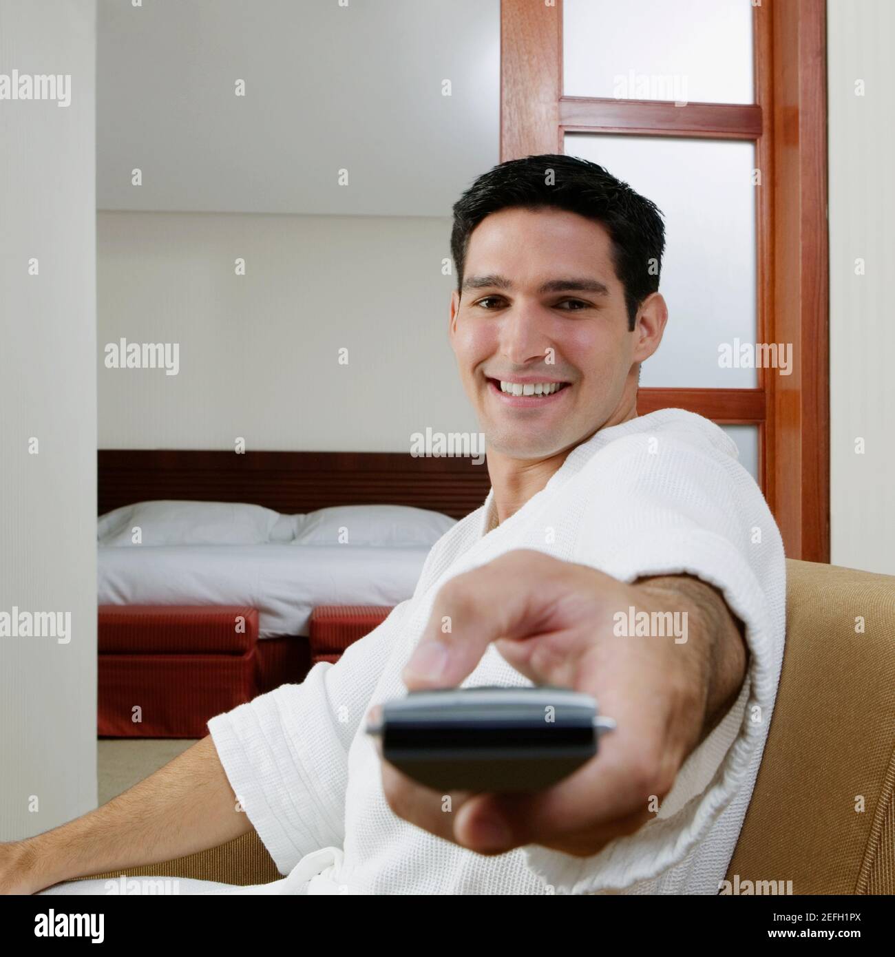 Side profile of a man holding a remote control hi-res stock photography ...