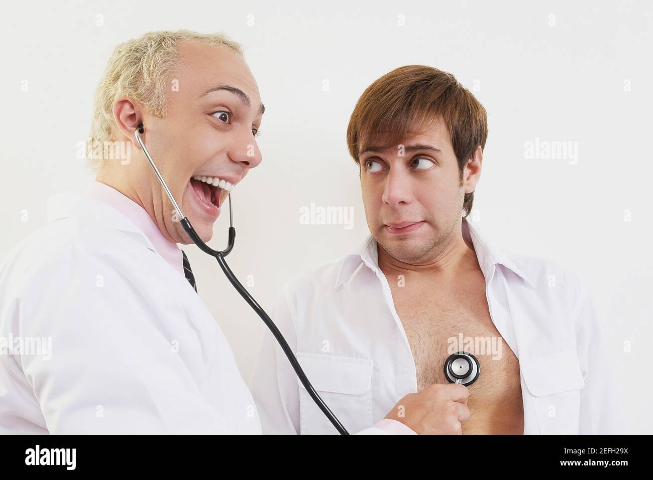 Side profile of a male doctor examining a patient with a stethoscope ...