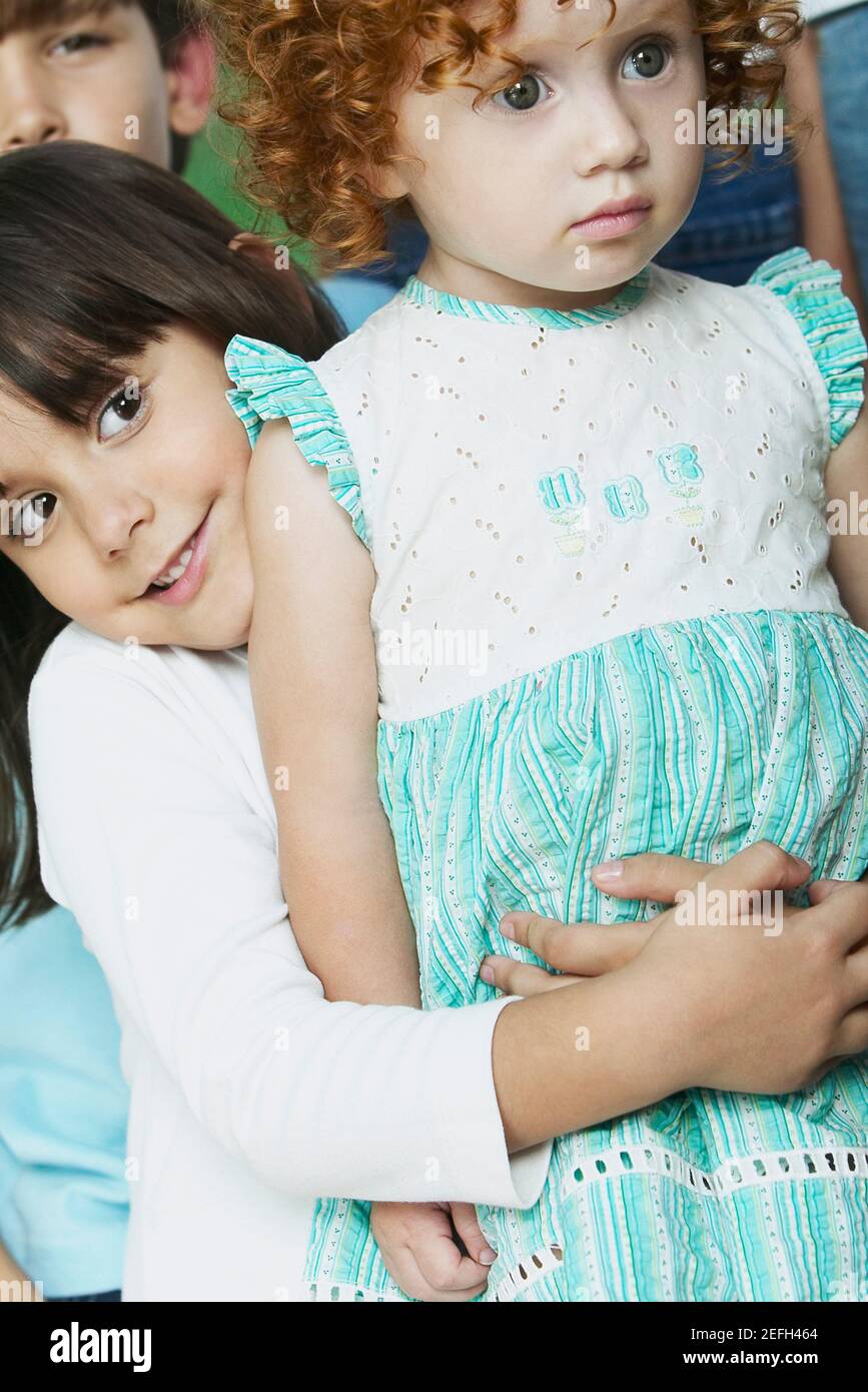 Close up of a boy hugging his sister from behind Stock Photo