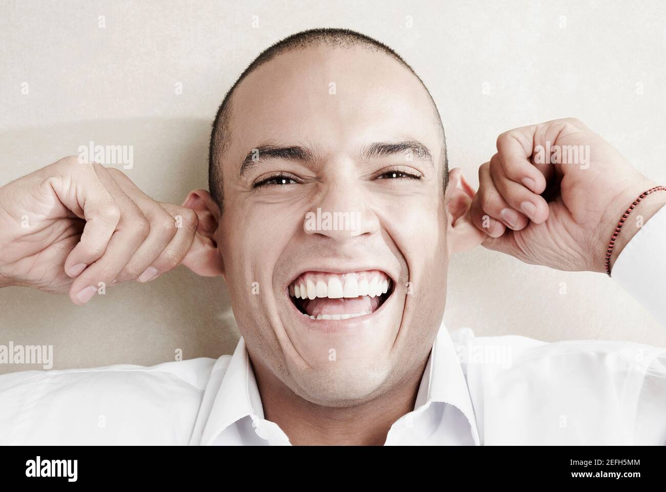 Portrait of a young man pulling his ears Stock Photo Alamy