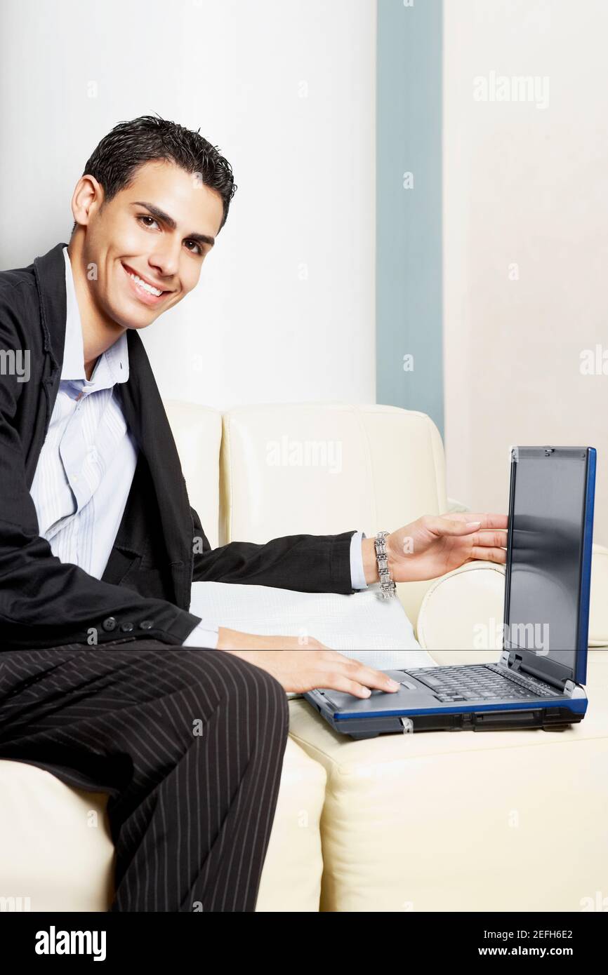 Portrait of a businessman sitting on a couch with a laptop Stock Photo ...