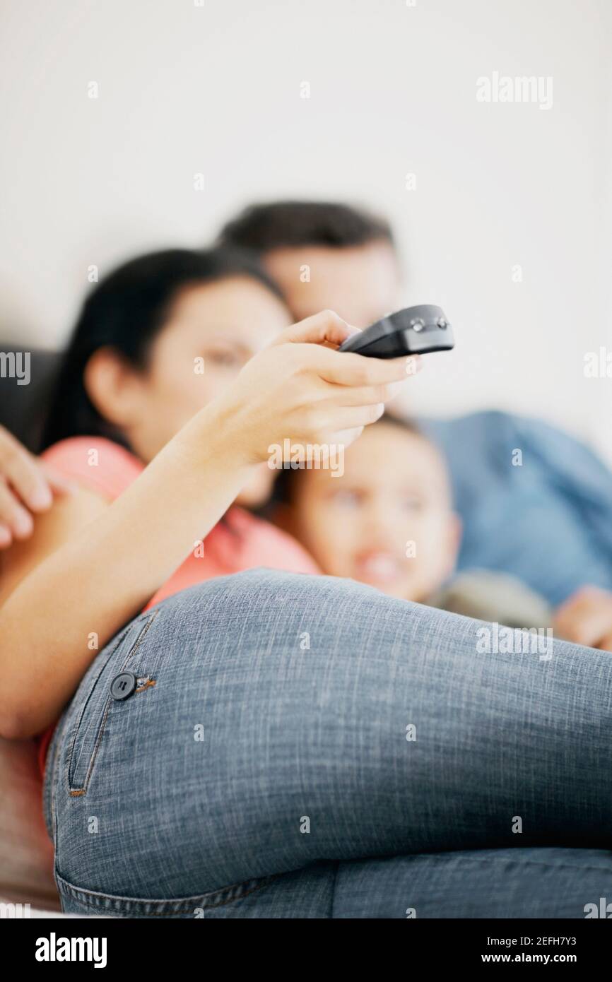 Boy watching television with his parents Stock Photo