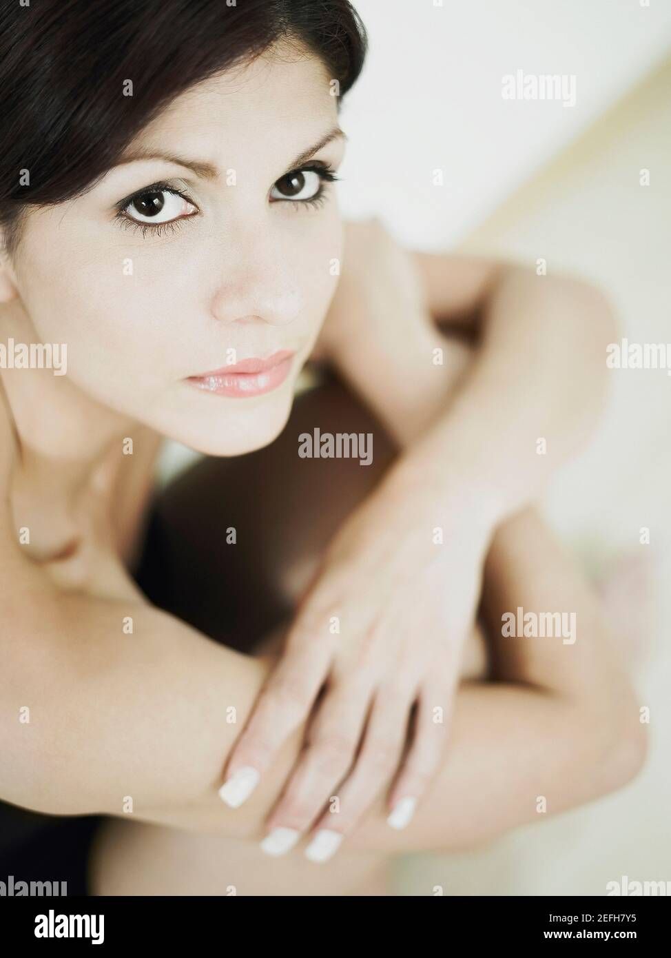 Portrait of a young woman sitting on the floor Stock Photo - Alamy