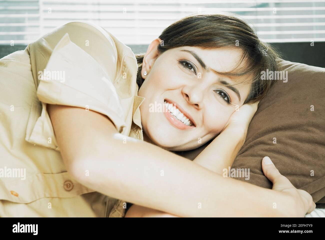 Portrait of a mid adult woman lying on her side and smiling Stock Photo ...