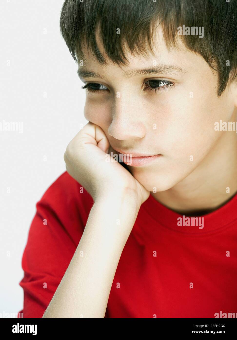 Close up of a boy with his hand on his chin Stock Photo