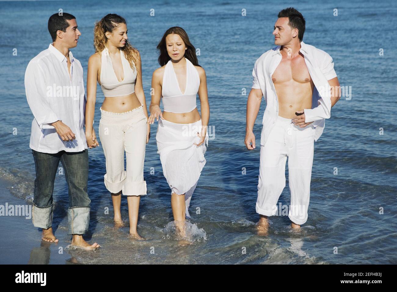 Two young women and a young man with a mid adult man walking on the ...