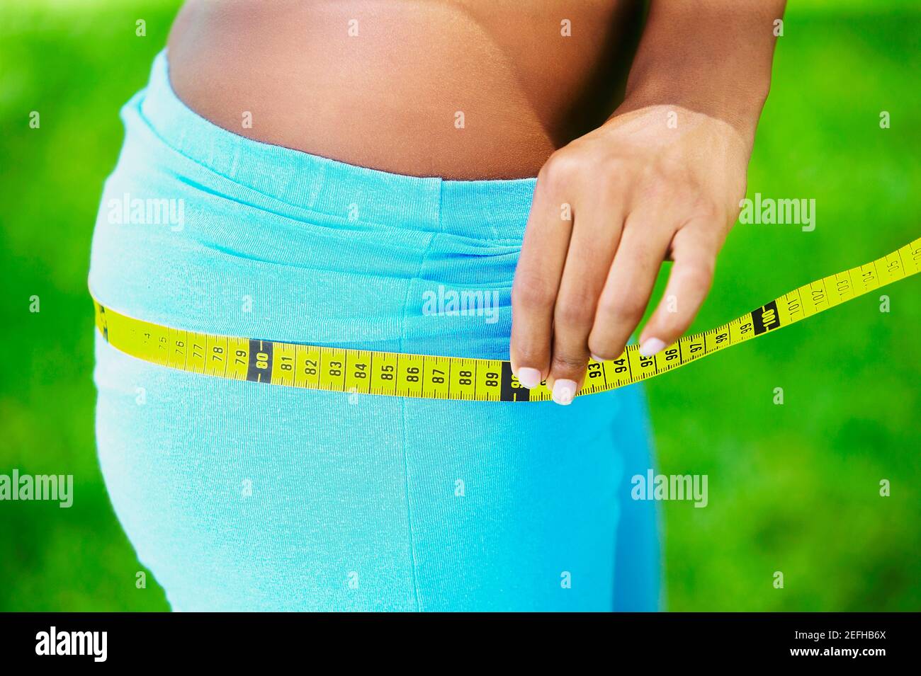 Close up of a woman measuring her hips with a tape measure Stock Photo