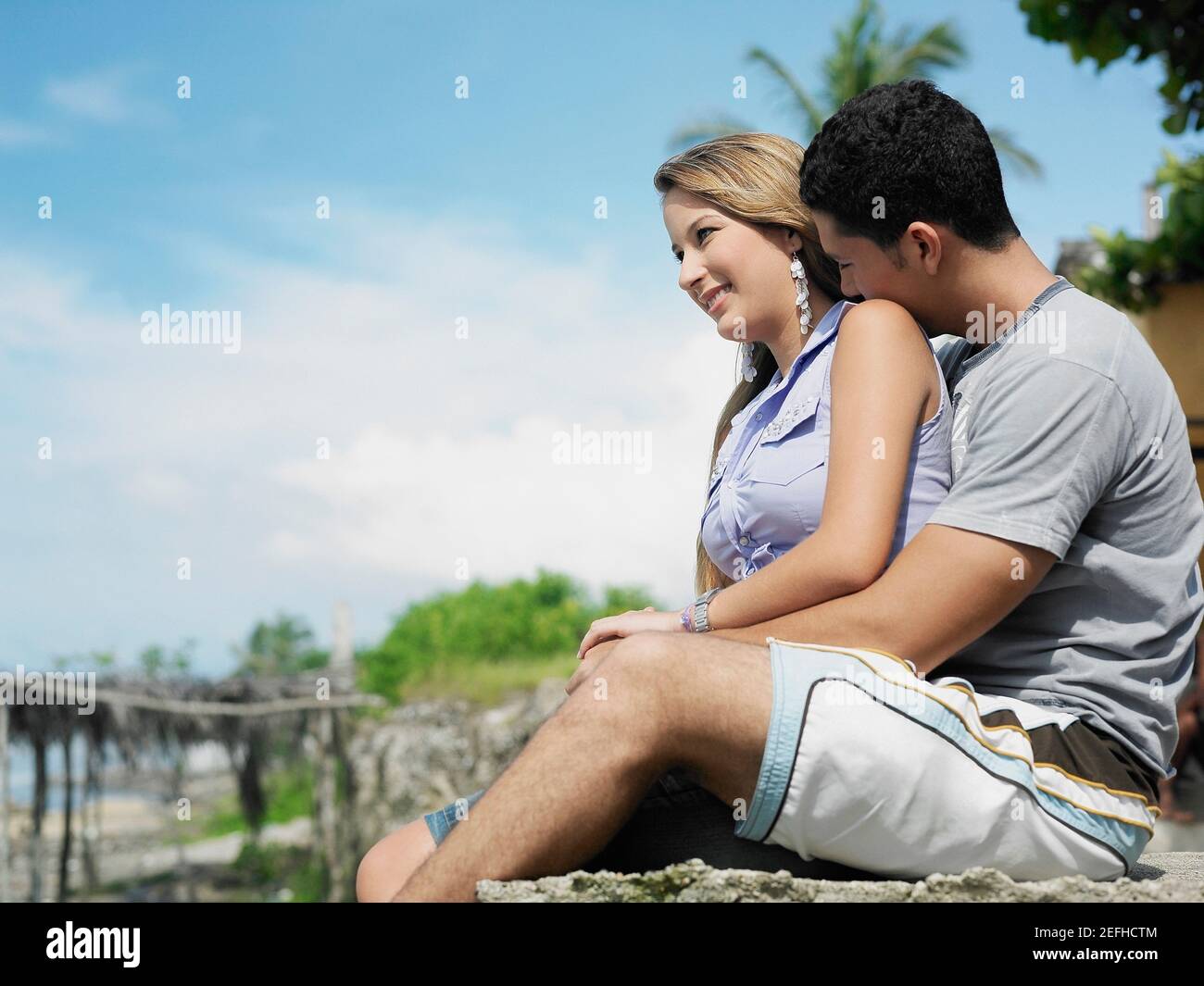 Side profile of a young man embracing a young woman from behind Stock ...