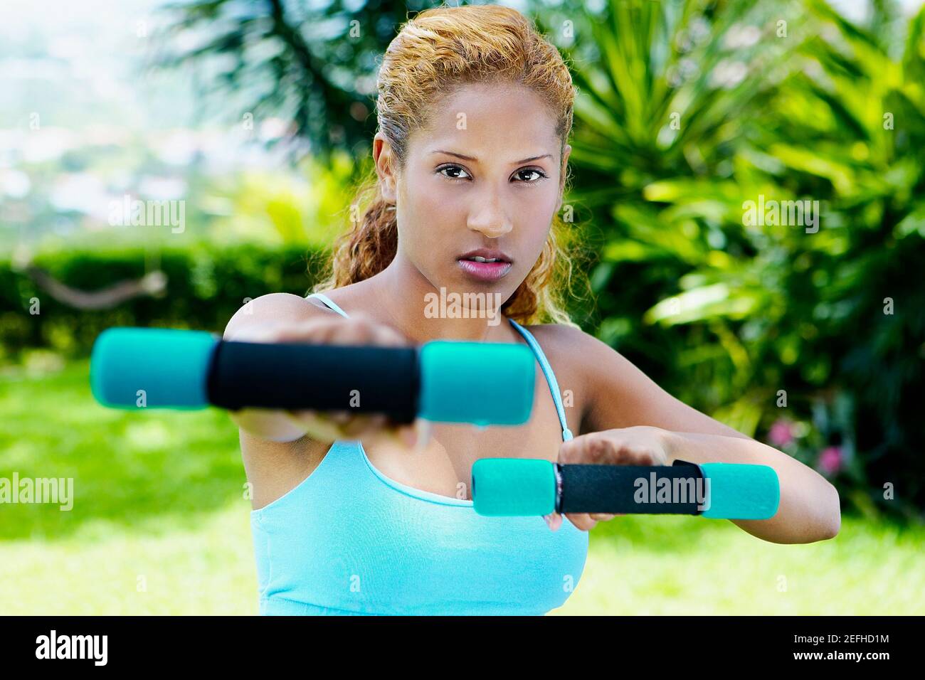 Portrait of a young woman exercising with dumbbells Stock Photo