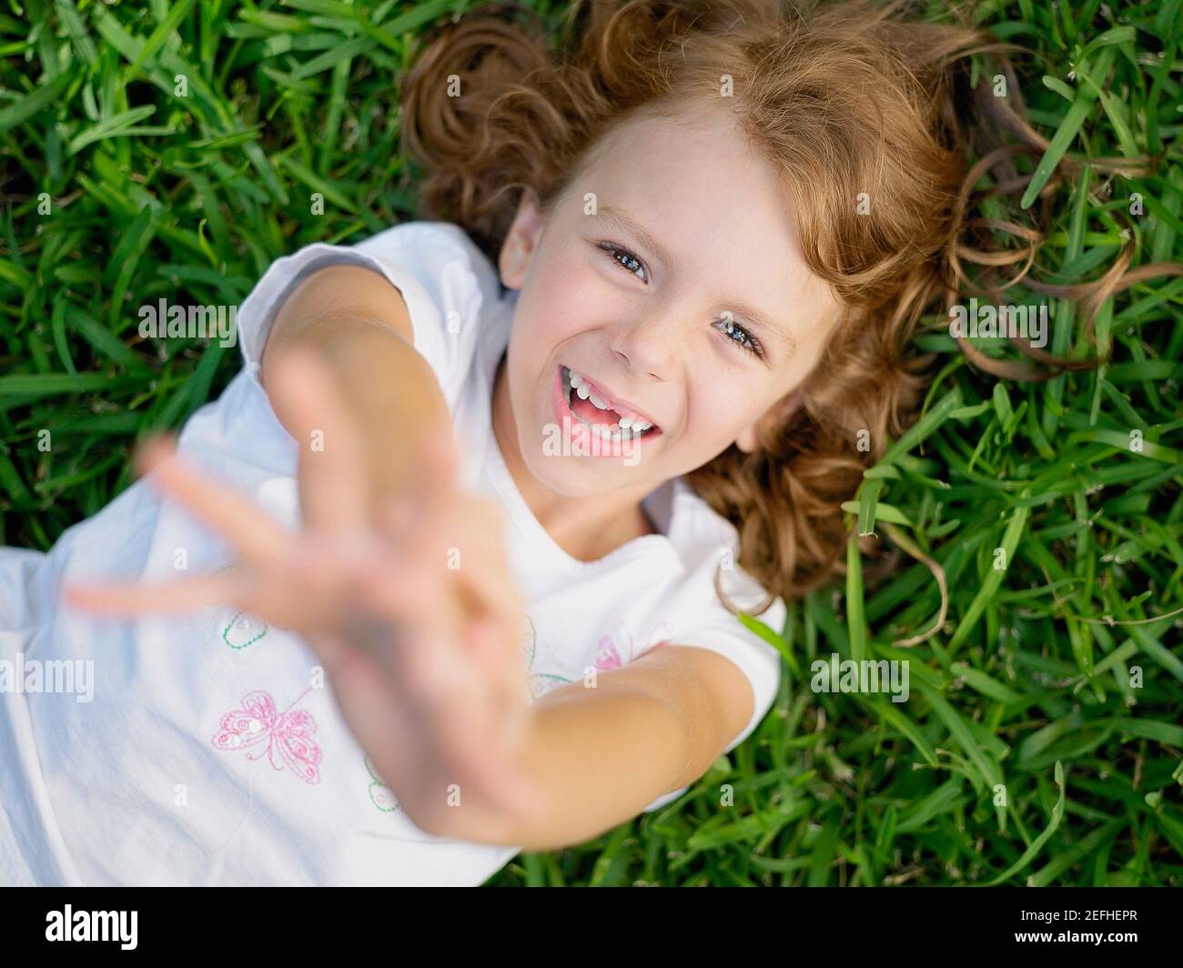 Portrait of a girl lying on the grass and smiling Stock Photo - Alamy