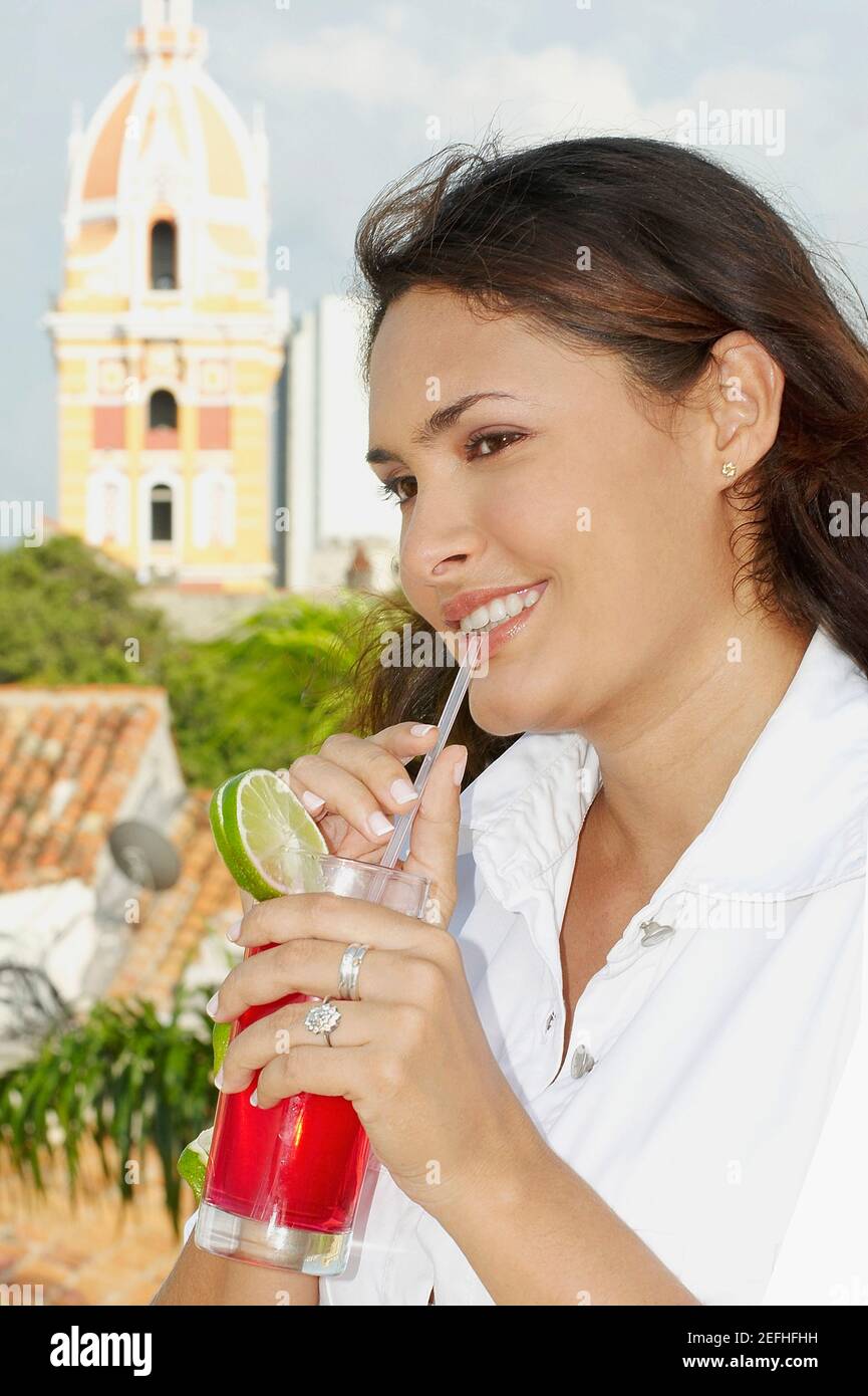 Close_up of a young woman drinking cocktail and smiling Stock Photo