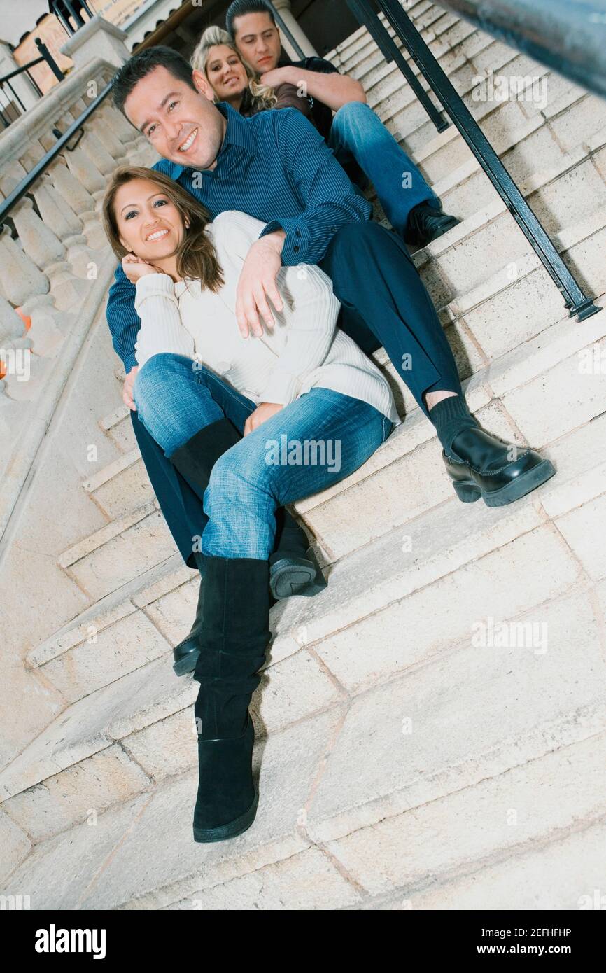 Low angle view of two young women and a young man with a mid adult man ...