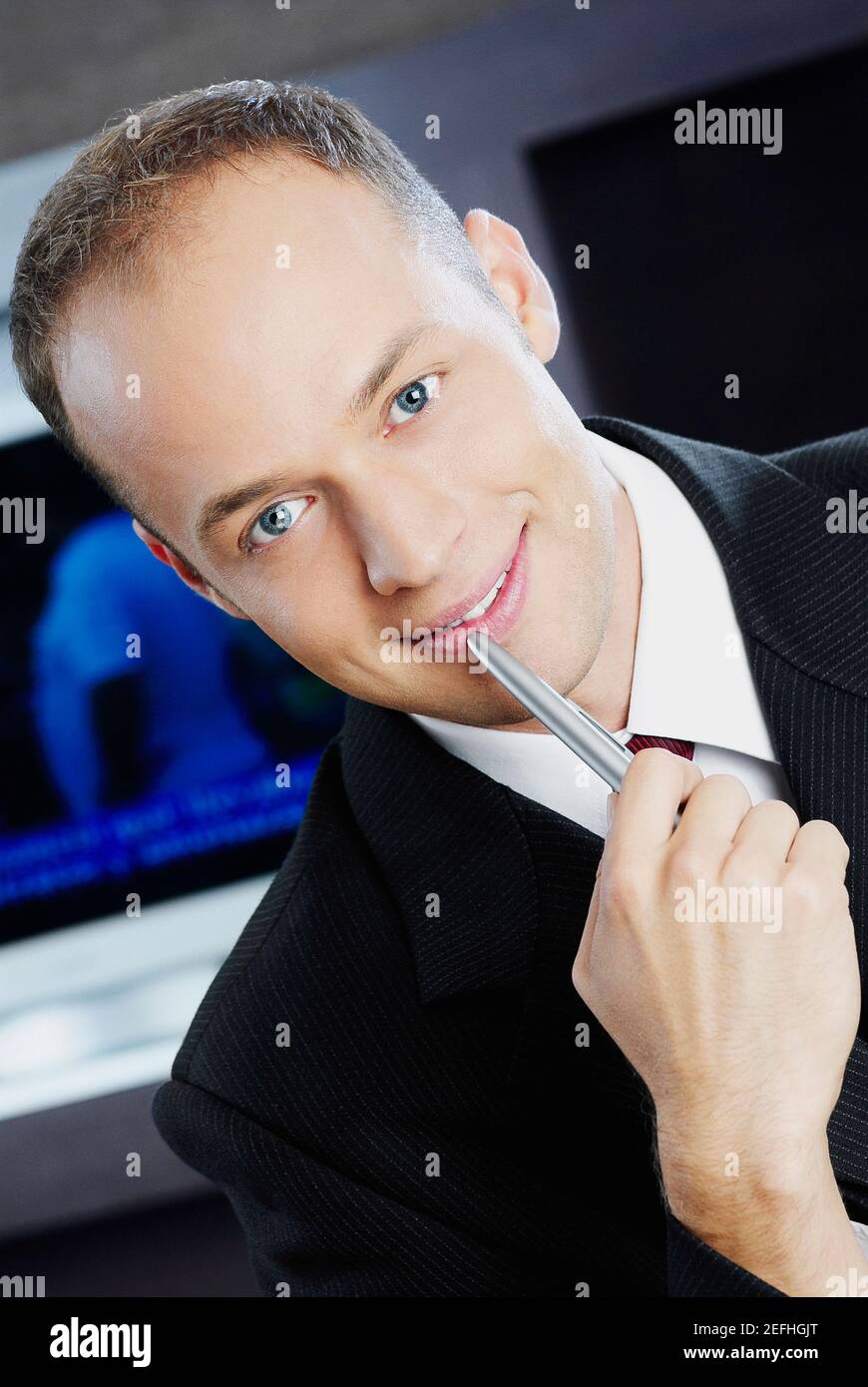 Portrait of a businessman holding a pen and smiling Stock Photo - Alamy
