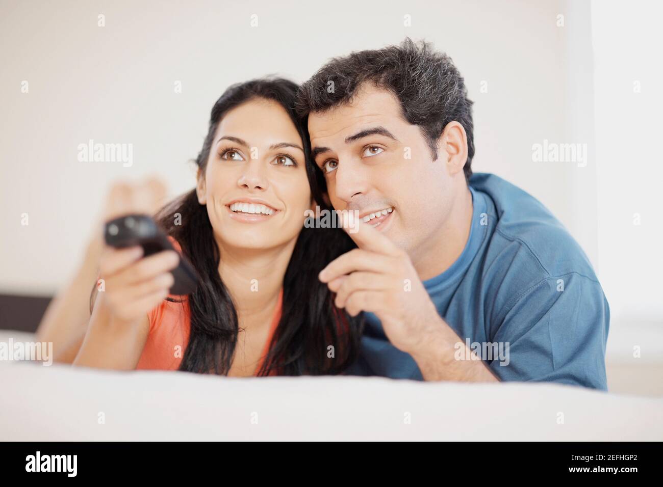 Close up of a young woman and a mid adult man lying on the bed and ...