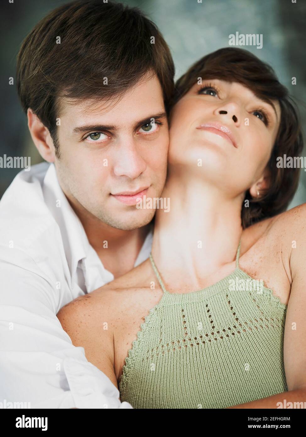 Portrait of a young man embracing a young woman from behind Stock Photo ...
