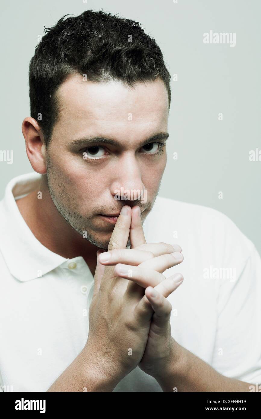 Portrait of a mid adult man with his fingers on his lips Stock Photo