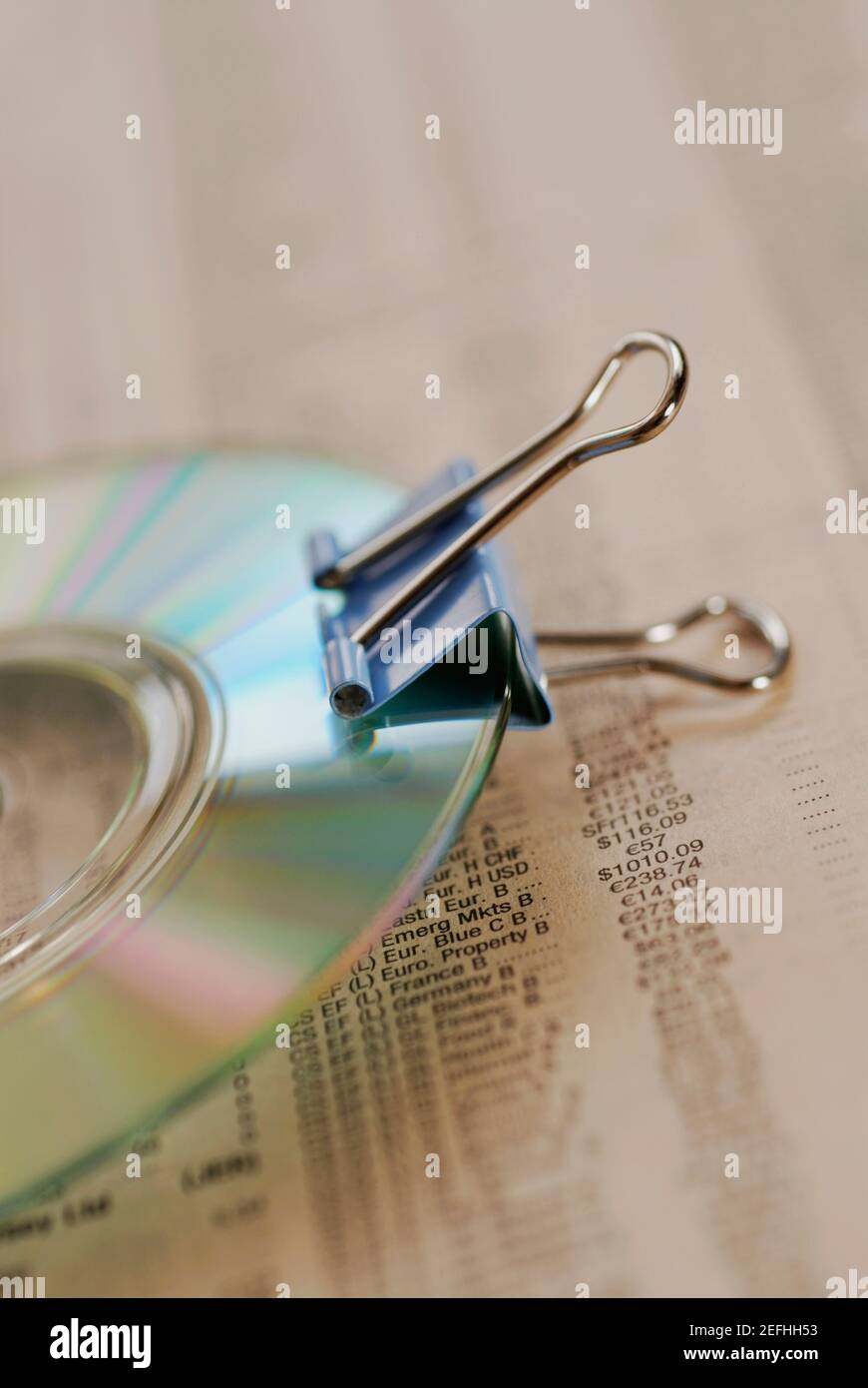 Close up of a CD with a paper clip on a financial page Stock Photo