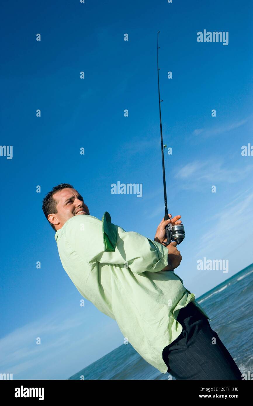 Side profile of a mid adult man holding a fishing rod on the beach Stock  Photo - Alamy