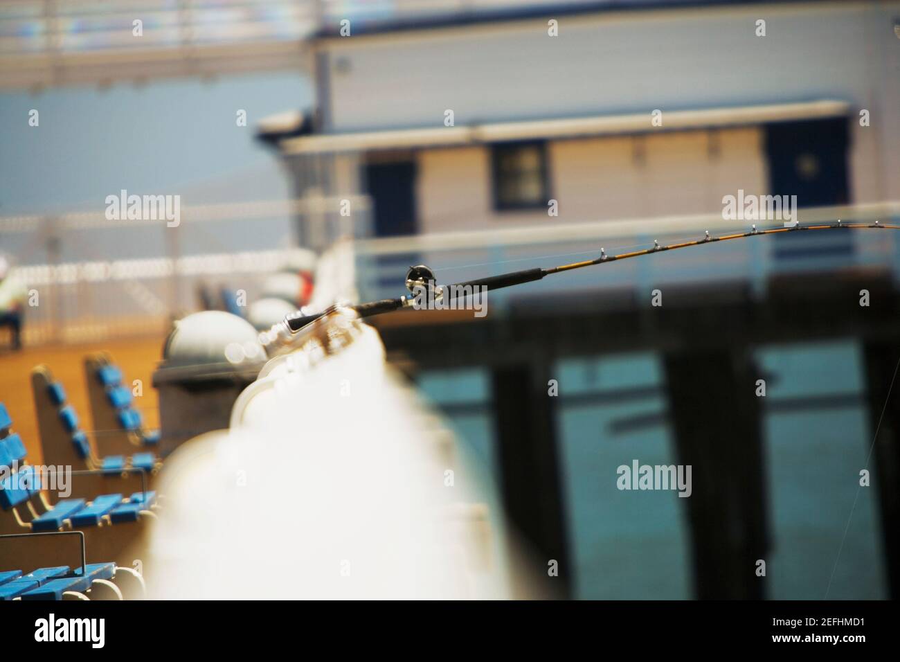 Side profile of a fishing pole on the ledge of a pier Stock Photo