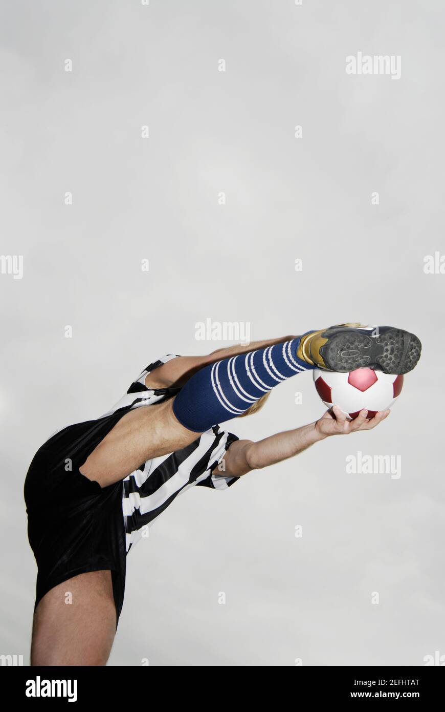 Low angle view of a soccer player kicking a soccer ball Stock Photo