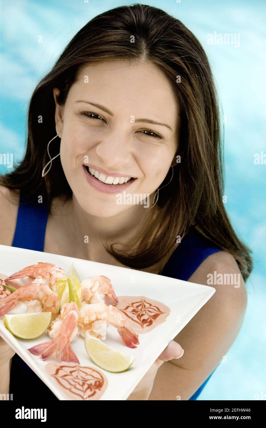 Portrait of a young woman holding food in a tray Stock Photo - Alamy