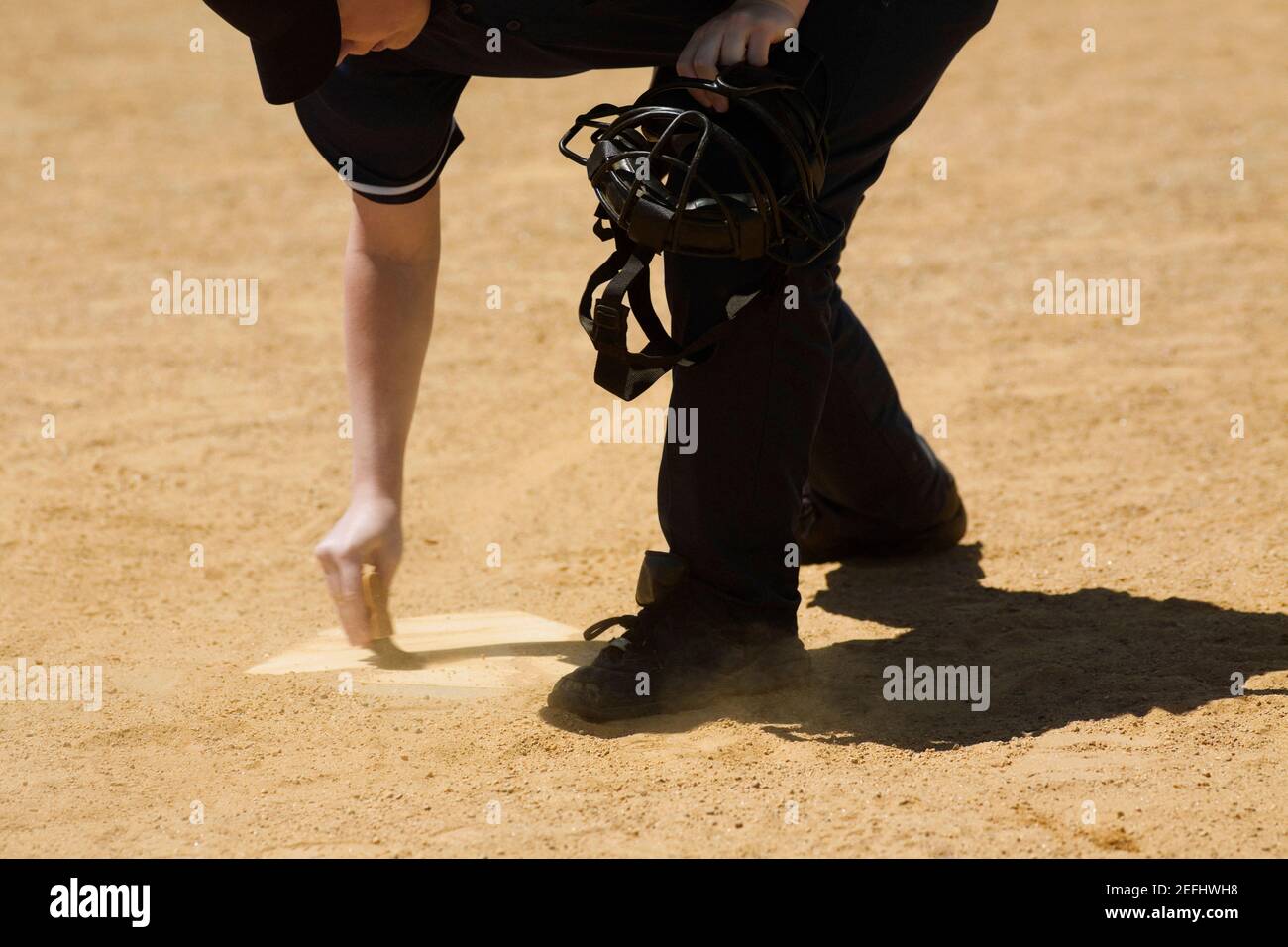 Side profile of a baseball umpire marking a baseball field Stock Photo