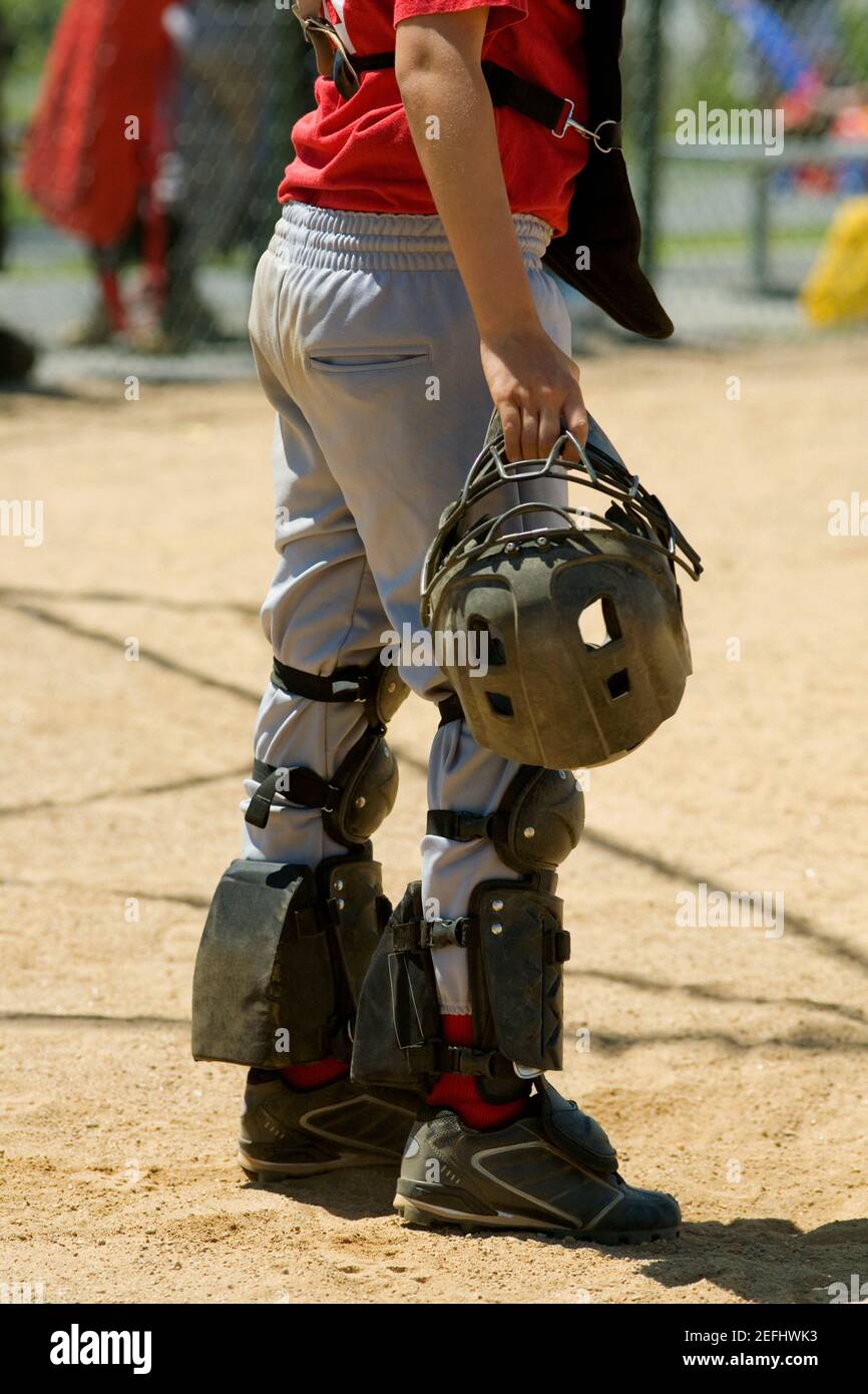 Low section view of a baseball catcher holding a helmet Stock Photo - Alamy