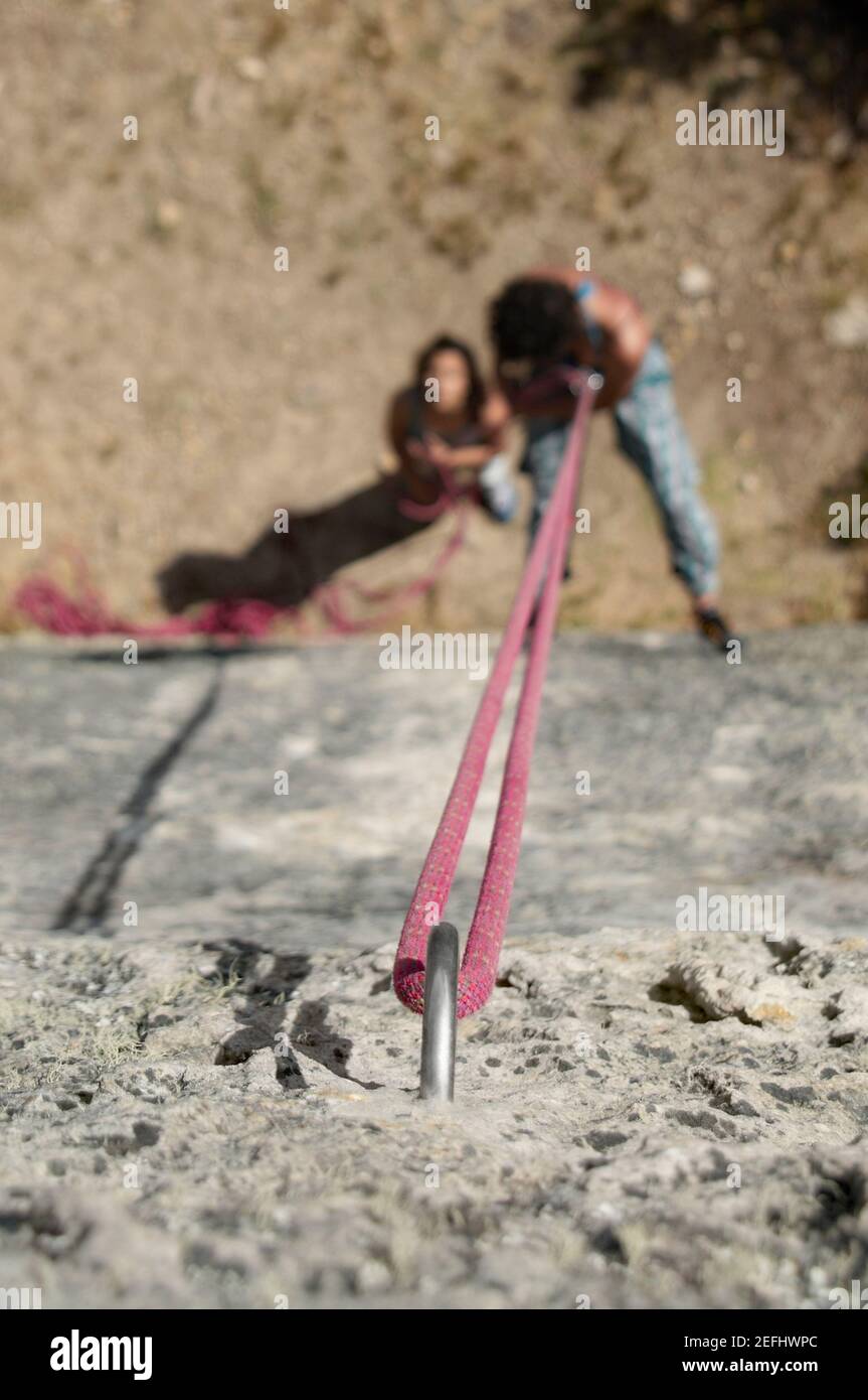 High angle view of a male rock climber scaling a rock with a female