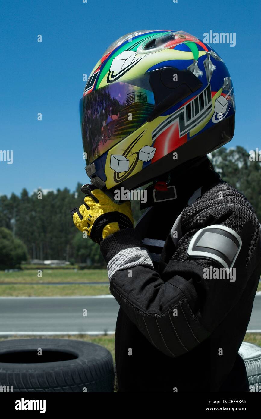 Side profile of a person adjusting his crash helmet Stock Photo - Alamy