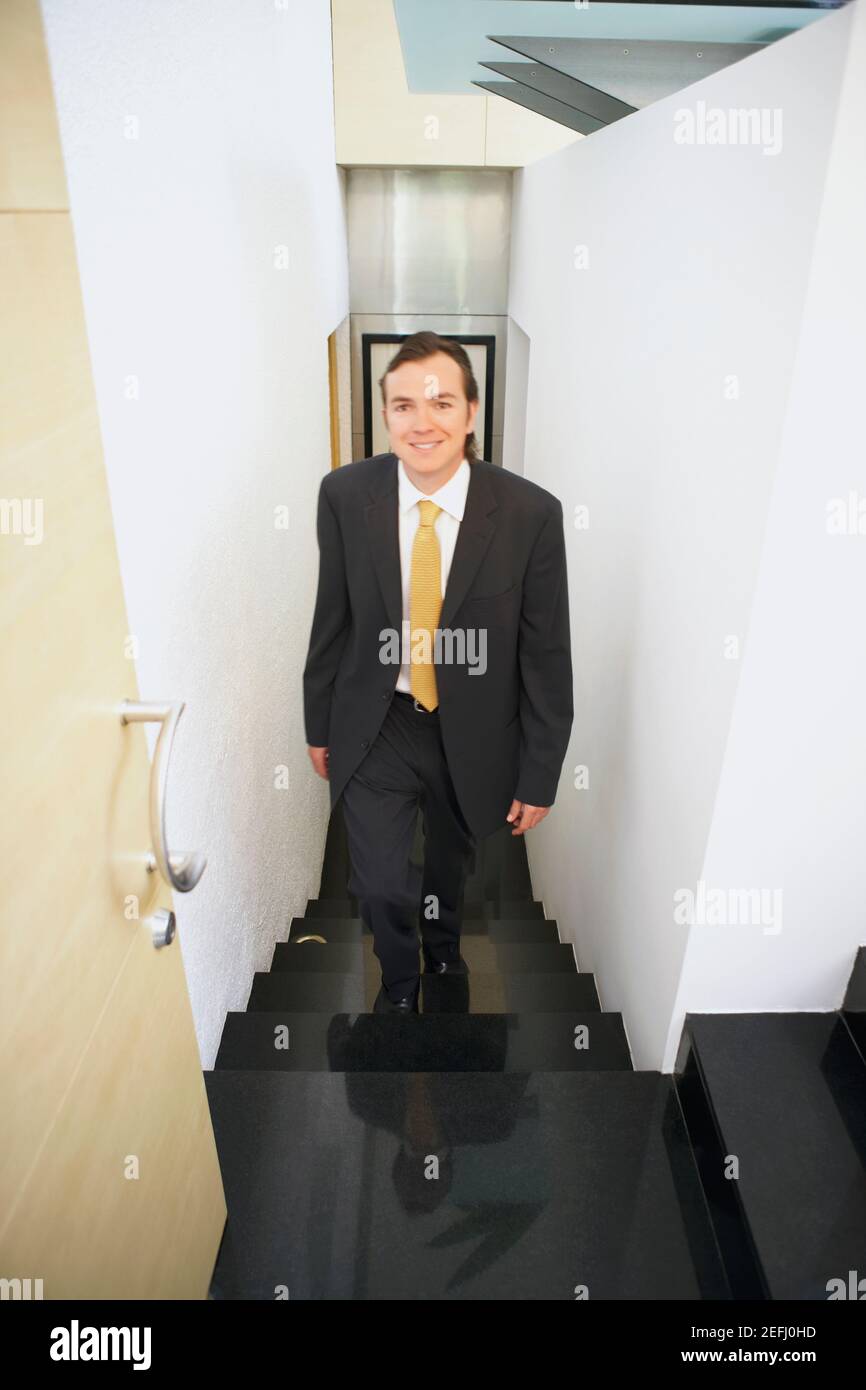Portrait of a businessman walking up stairs Stock Photo - Alamy