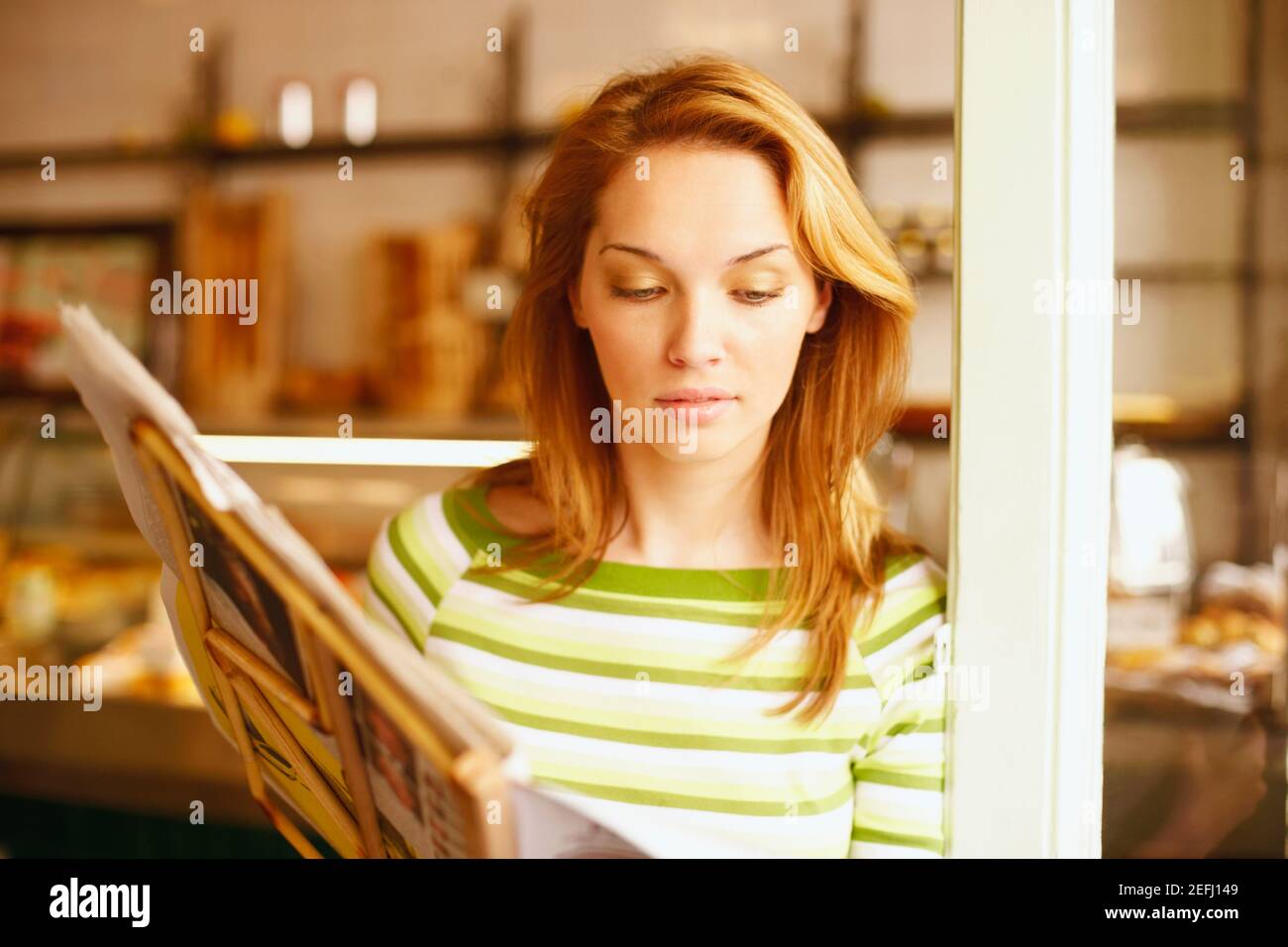 Close-up of a young woman reading a menu card Stock Photo